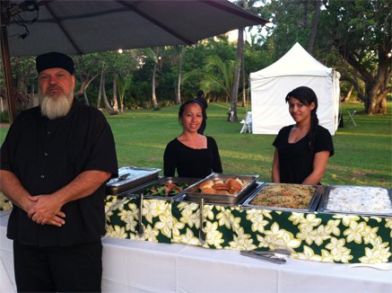 Keneke's staff in black behind a buffet of stainless steel warmers