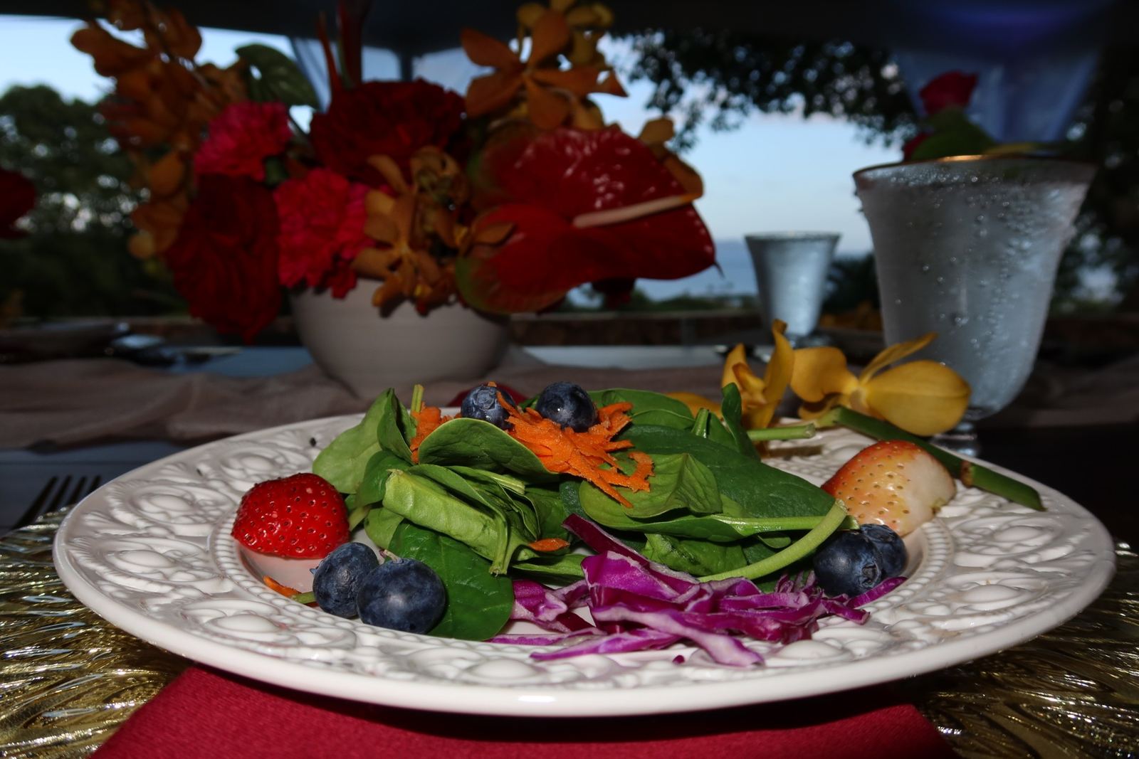 Spinach salad with berries on a white plate at a wedding table